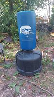 Blue Wave Master adjustable punching bag with black weighted base outdoors on the ground, showing the front with branding and overall condition.