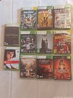 Photo of 12 video game cases laid out on a white surface showing various Xbox and Xbox 360 game titles.