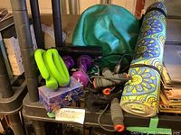 Overview of exercise equipment including green exercise ball, yoga mat, purple and green dumbbells, exercise bands, and jump rope.