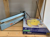 Photo showing impulse sealer and Oxford letter size frame kit with hanging folders on wooden shelf