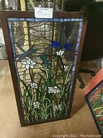 Full frontal view of stained glass panel including frame and hanging chain