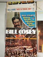 Photo showing multiple Bill Cosby albums stacked: The Best of Bill Cosby, Why Is There Air?, Hooray for the Salvation Army Band, and Live at Madison Square Garden Center