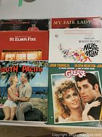 Overview photo showing front covers of identified soundtrack albums including Grease, South Pacific, My Fair Lady, The Music Man, and St. Elmo's Fire.