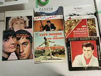 Photo showing 8 vinyl record albums with varied cover art from different artists including Ian & Sylvia, Bobby Rydell, Cliff Richard & The Shadows, The Pogues, Zamfir, Lonnie, and Palladium Performances.
