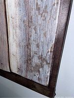 Close-up showing distressed wood plank pattern of vinyl material and dark brown border corner
