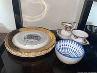 Royal Albert "Celebration" creamer and sugar bowl on matching floral and gold trimmed tray, Johnson Brother Victorian plate and other commemorative plates, blue and white patterned bowl