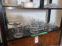Photo showing seven glass bowls of different sizes and shapes on a shelf, some footed and some simple bowls.