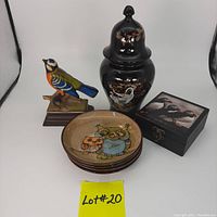 Overview of lot showing Japanese ginger jar with crane design, colorful bird figurine on wooden base, 4 owl design plates stacked, and black box with puffin design coasters.