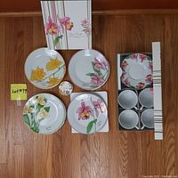 The full dessert set including four dessert plates each with different Costa Rican floral designs, four white cups and their matching saucers with floral decorations, and the original boxes.