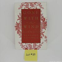 Front cover of Gone With the Wind 60th Anniversary Edition hardcover book showing white dust jacket with red floral pattern and title block.