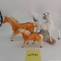 Front and side view showing all three horses: large glossy white/grey running horse, large matte trotting palomino, and small matte walking palomino with repaired leg.