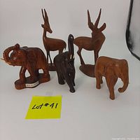 Front view of five wooden animal figurines including three elephants and two antelopes in different wood tones, arranged with sticky note 'Lot #41'