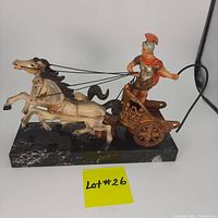 Front view of the Roman charioteer figurine with horses and black marble base