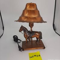 Front view of vintage copper-finished horse lamp with scalloped multi-tiered lampshade and replaced electrical cord.