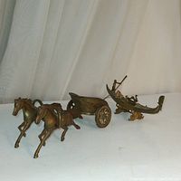 Photo showing the front and side views of the two brass figurines, the chariot with two horses and the gondola with figures