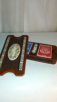 View of the open cribbage board showing playing cards and pegs in the drawer compartment