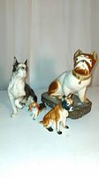 Four dog figurines arranged together showing different sizes and breeds: French Bulldog, Boxer (two), and Beagle