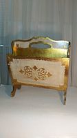 Front view of vintage Italian Florentine magazine holder showing ornate gilt gold finish and floral motifs.
