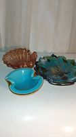 Lot of three vintage Murano art glass pieces on white surface with cloth background