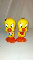 Front view of both vintage Tweety Bird bobbleheads side by side showing painted details and size.