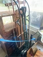 Photo of vintage wooden Champion sled and two snow shovels leaning against a screened porch wall