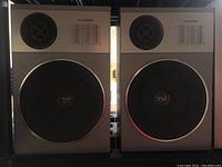 Pair of Lloyd's S-HTD540 Series 193-A speakers showing front view with woofer and tweeter grills and frequency response chart.