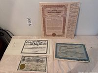 Overview photo of all four vintage certificates laid out on a surface.