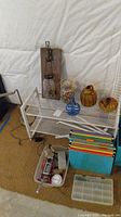 Wide view showing shoe rack with jars, glass pumpkins, file folders, and bike jack in plastic bin under rack