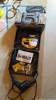 Overview of all items including DeWalt jig saw in case, Dremel tool, APC battery backup, and manual.