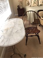 Side view showing marble surface and Windsor chair near window.
