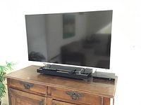 Sony TV, home theater soundbar and Blu-ray player on wooden console