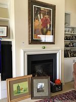 View of three framed wall art pieces arranged near fireplace, showing size and context.