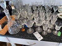 Wide view of decanter and mixed stemware glasses arranged on counter