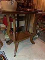 View showing side and leg detail of the wood hall table including lower open shelf.