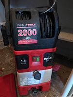 Front view of the Clean Force pressure washer showing the 2000 PSI and 1.5 GPM labels, power switch, and hose connection port.