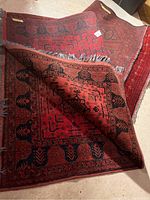 Two red rugs overlapped, showing overall size and pattern