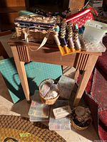 Overall lot showing wooden table with various sewing supplies on top and underneath, including thread spools and organizers