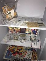 Shelf with various stamps and envelopes organized in sleeves and plastic bags