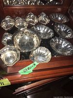 12 sterling silver dishes and bowls on mirrored surface