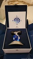 Swarovski Crystal Planet Vision 2000 figurine in blue crystal globe with a clear crystal bird perched on top, displayed in its original box with certificate.