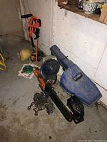 Overview of three power tools on floor against wall