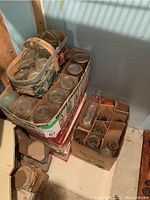 Photo showing stacked boxes of home preserving jars labeled Consumers Glass and vintage basket holding Mason jars.