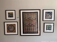 Photo of five framed fabric art prints arranged on a wall, showing size and framing style