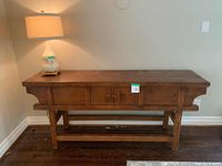 Full view of the solid wood oriental entertainment table with three front compartments and natural wooden finish, lamp not included.