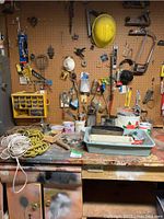 Workbench and pegboard with most items displayed hung or on surface