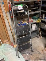 Metal step ladder with two wide slip-resistant steps and a top platform, showing paint splatters and wear.