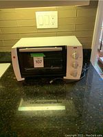 Full front and side view of white toaster oven on countertop showing controls and condition