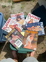 Top view of six vintage Playboy magazines showing classic covers and bold titles.