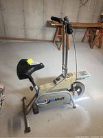 Side angled view of the Voit exercise bike showing the padded seat, handlebars, and flywheel area with Voit branding.