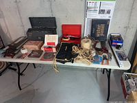 Full view of two tables with various tools, two toolboxes, rope coils, and accessories arranged on them